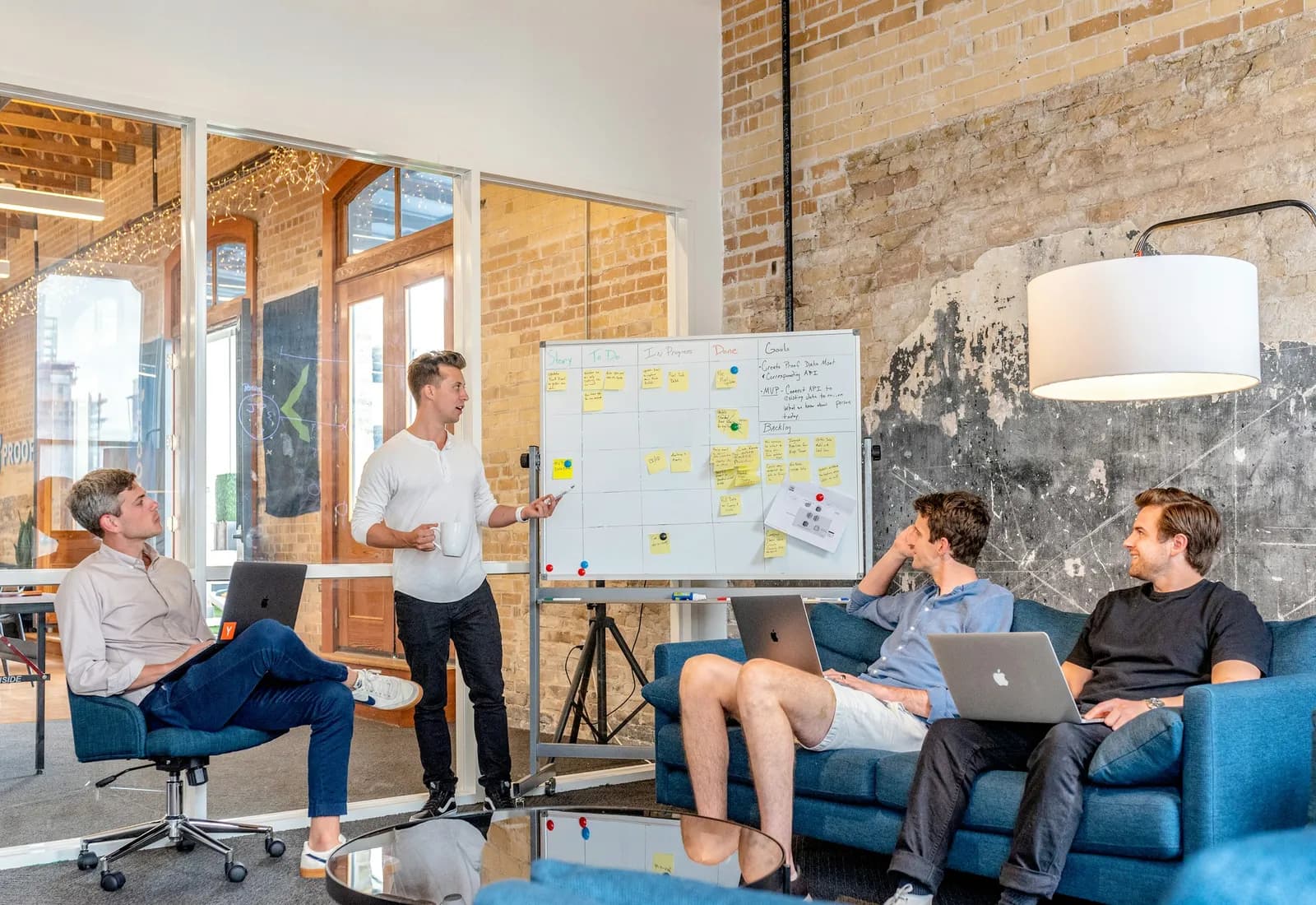A team mapping out a process on a whiteboard in an open office